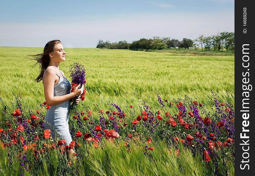 Young happy girl with bouquet in wheat field. Young happy girl with bouquet in wheat field