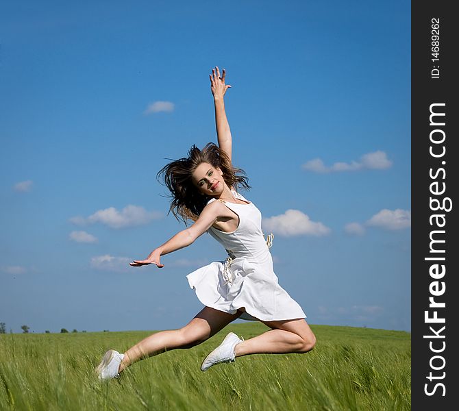 Young happy girl jumping in green field. Young happy girl jumping in green field