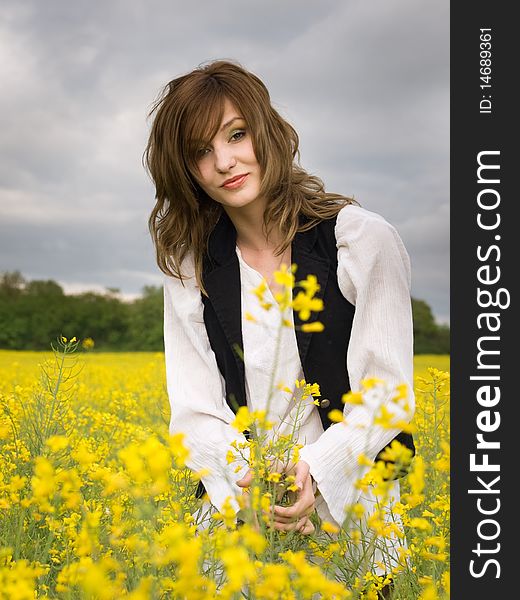 Young girl resting in rape field. Young girl resting in rape field