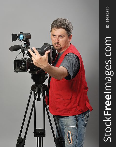 Cameraman in red vest, shows gesture