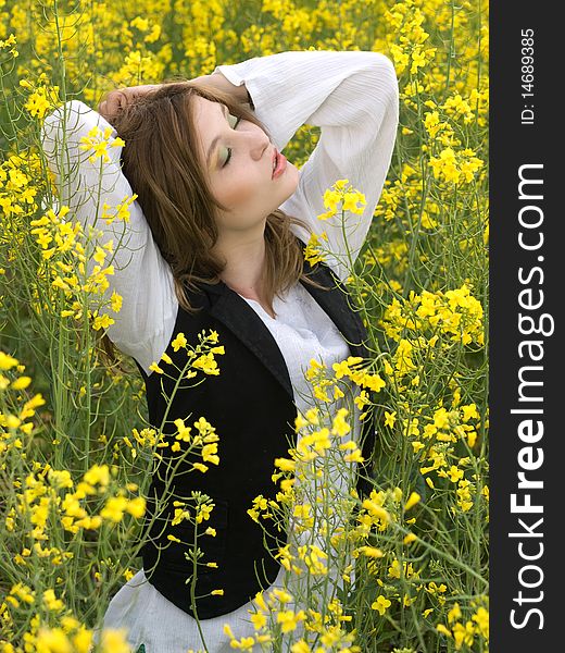 Young girl resting in rape field. Young girl resting in rape field