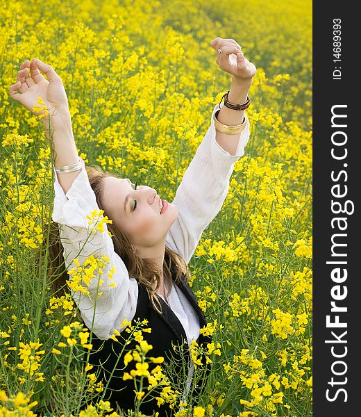 Young girl resting in rape field. Young girl resting in rape field