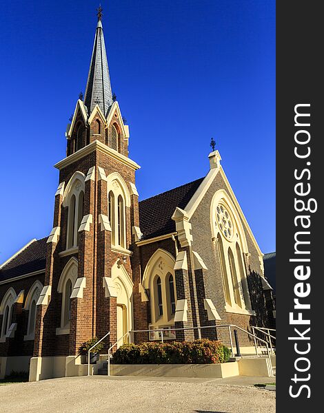 Facade of St Paul Presbyterian Church, built in 1881-82 in Gothic Revival design with a tall steeple, arched lancet windows and an impressive rose window, in Armidale, NSW, Australia