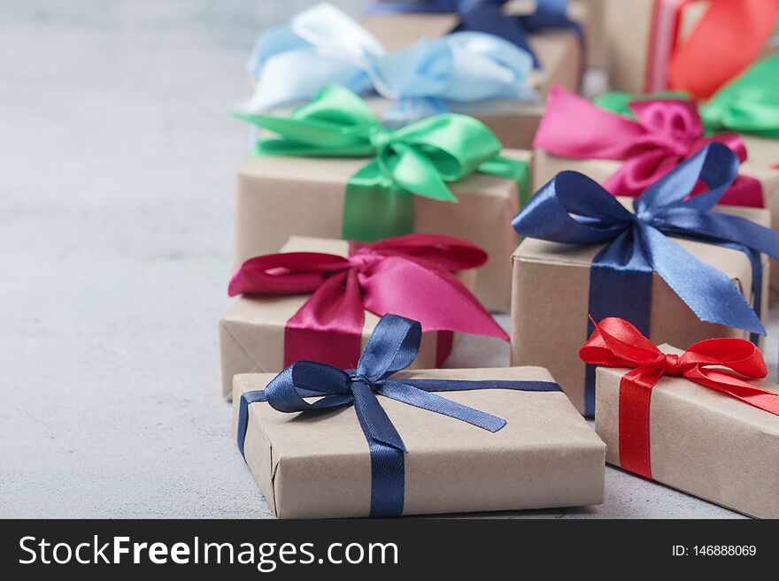 Boxes with presents and gifts wrapped with craft paper and colorful satin ribbons. Boxes with presents and gifts wrapped with craft paper and colorful satin ribbons