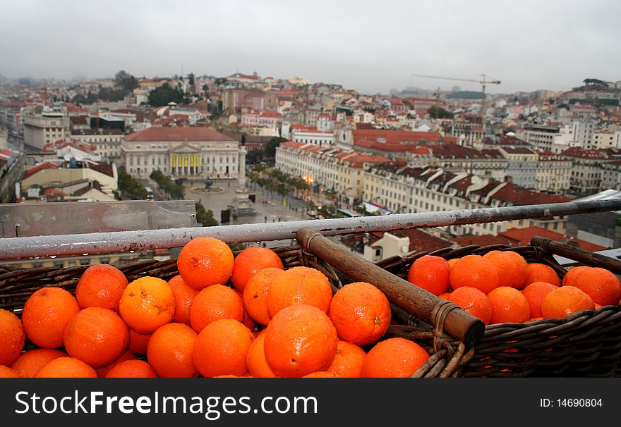 A basket of oranges on a terrace overlooking the city of Lisbon. A basket of oranges on a terrace overlooking the city of Lisbon