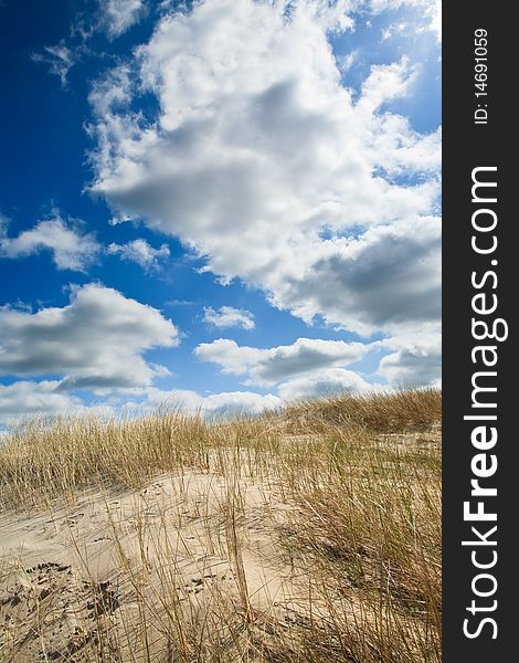 Sand dunes near to the sea with cloudy sky