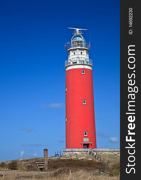 Lighthouse in the dunes at the beach with blue sky