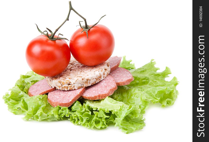 Sandwich with sausage from small loaf of bread, tomatoes and salad. Sandwich with sausage from small loaf of bread, tomatoes and salad