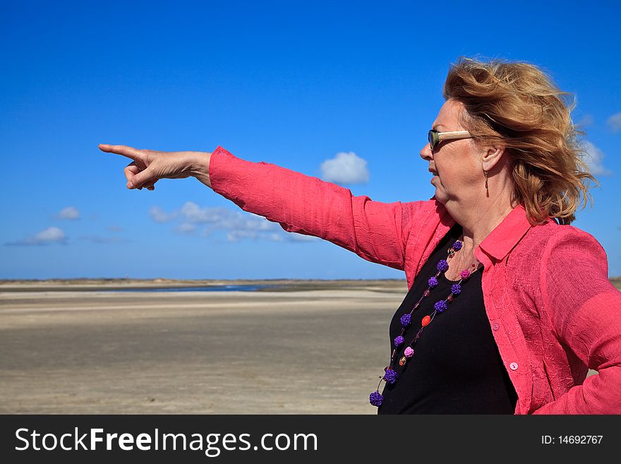 Red haired woman pointing to the sea