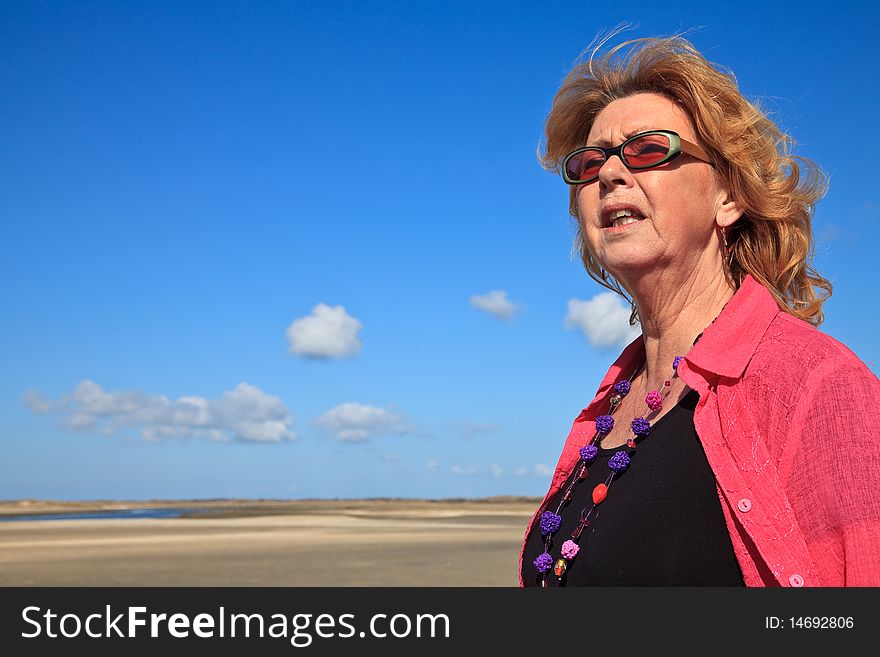 Red haired woman looking to the sea on a sunny day