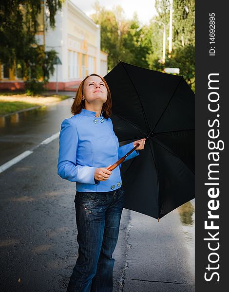 Girl under umbrella watching the rain falling down. Girl under umbrella watching the rain falling down