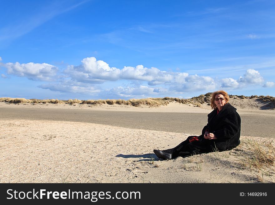 Woman Sitting In The Sand Dunes