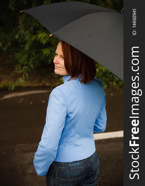 Girl under umbrella watching the rain falling down. Girl under umbrella watching the rain falling down