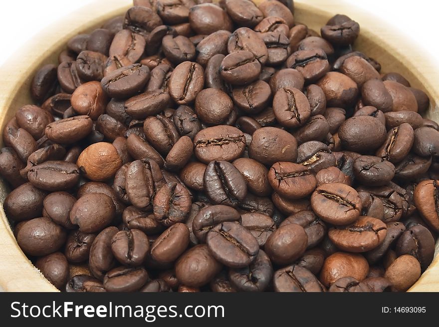 Roasted coffee beans in a wooden bowl. Roasted coffee beans in a wooden bowl