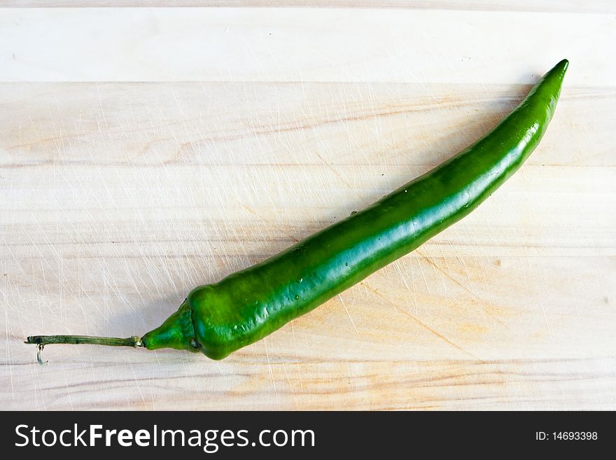 Green hot pepper on chopping board