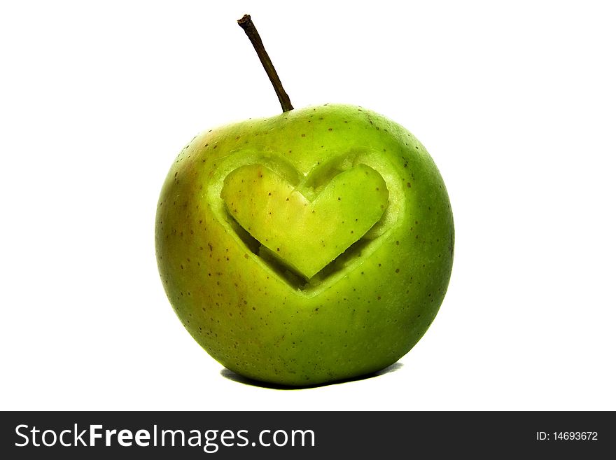 Mark of heart cut out by a knife on a green apple. Mark of heart cut out by a knife on a green apple