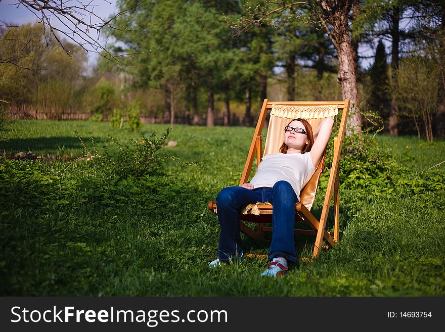 Pregnant girl in chair in garden. Pregnant girl in chair in garden