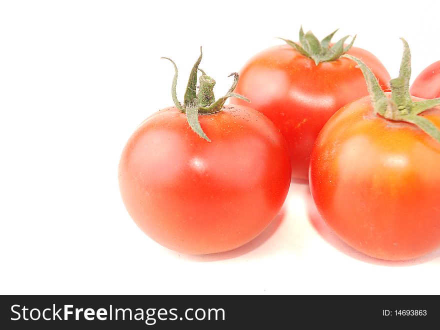 Bitter pepper of red colour and tomatoes on a white background. Bitter pepper of red colour and tomatoes on a white background