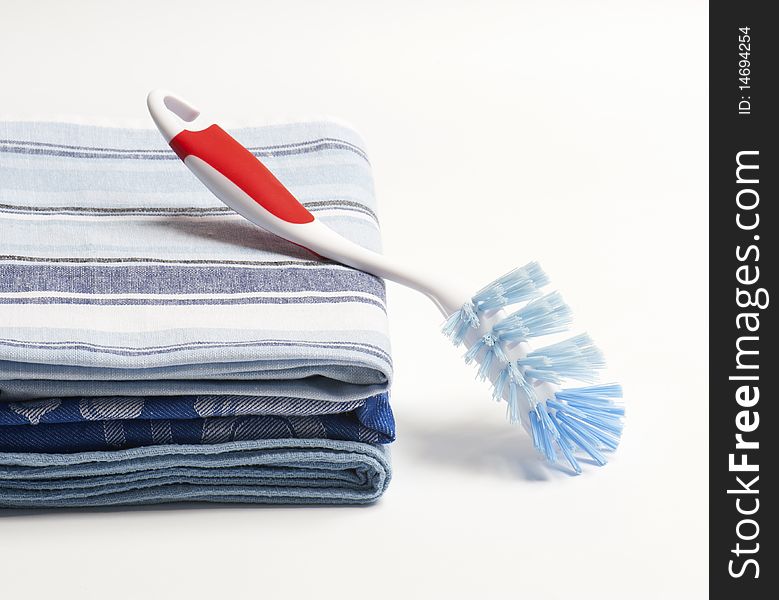 Three Folded Drying Cloths With A Washing Up Brush. Three Folded Drying Cloths With A Washing Up Brush