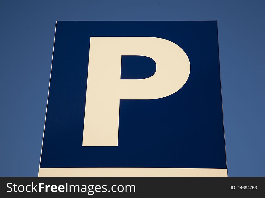 Close-up of parking sign against blue sky background. Close-up of parking sign against blue sky background