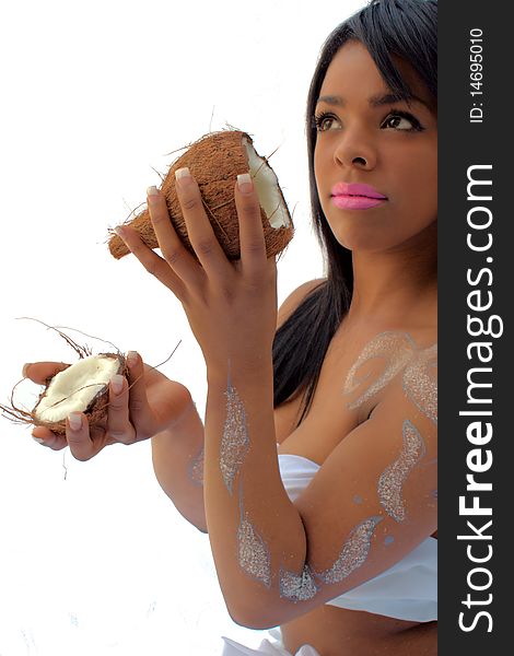 Young woman holding up two coconut halves. Young woman holding up two coconut halves