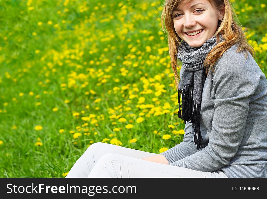 The young girl, sits on a green grass, in park. The young girl, sits on a green grass, in park