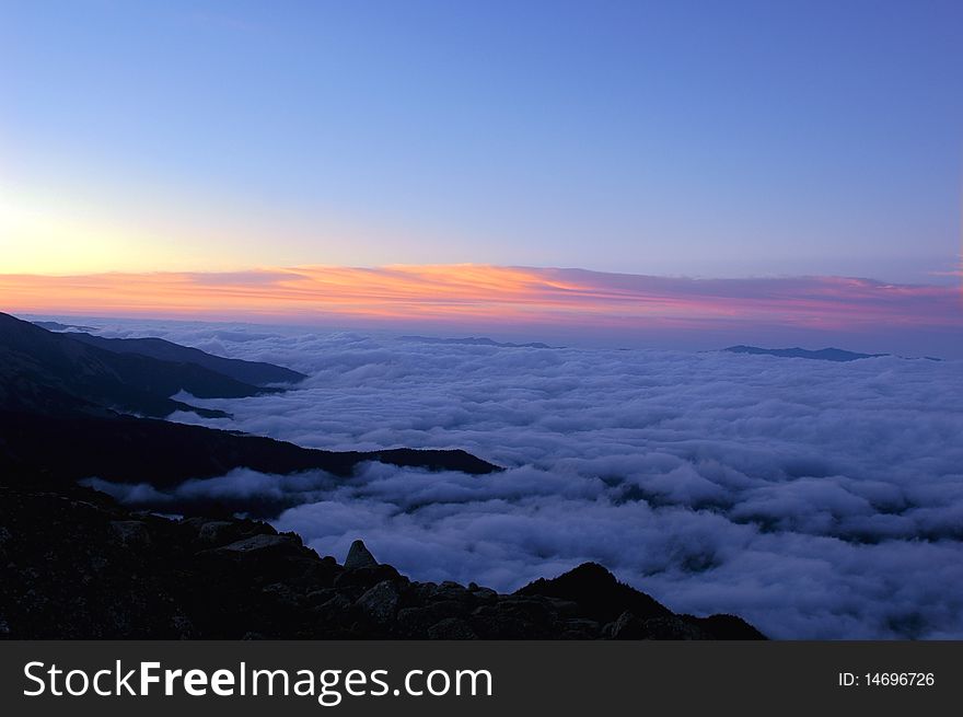 Mountains in the sea of clouds with blue sky and sunglow at daybreak