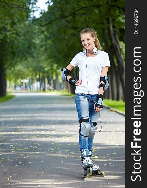 The young girl on rollers in park. The young girl on rollers in park