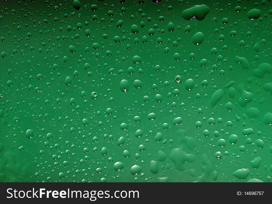 Drops from water on green colour of a background