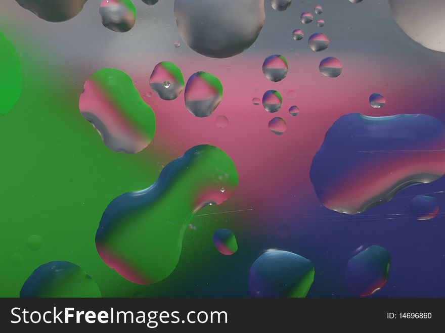 Multi coloured drops from water on glass