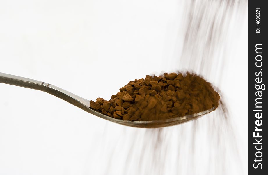 A spoon full of coffee on a white background