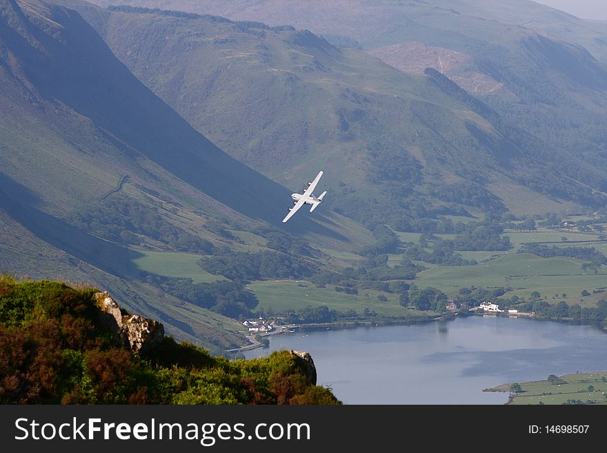 An RAF Hercules banks over a lake and into a Welsh valley. An RAF Hercules banks over a lake and into a Welsh valley