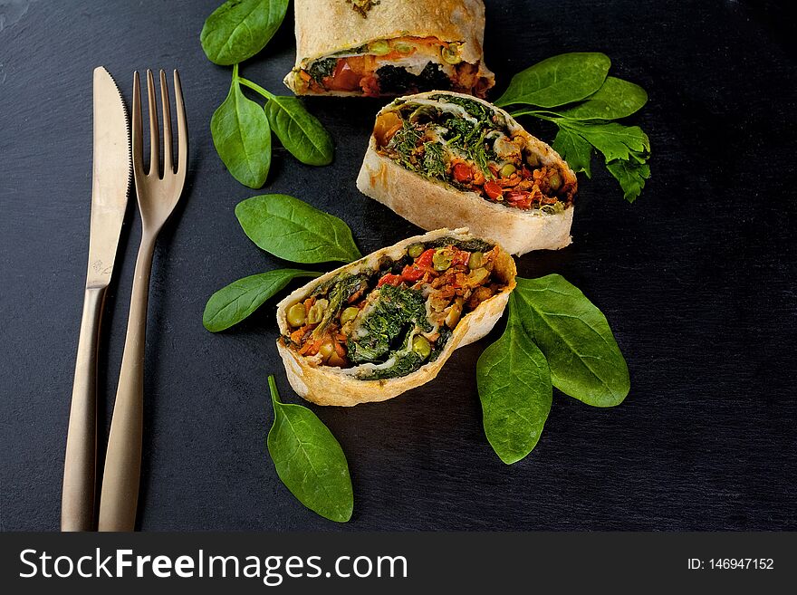 Vegetable savory strudel, with tomatoes, bell pepper, mushrooms on black background