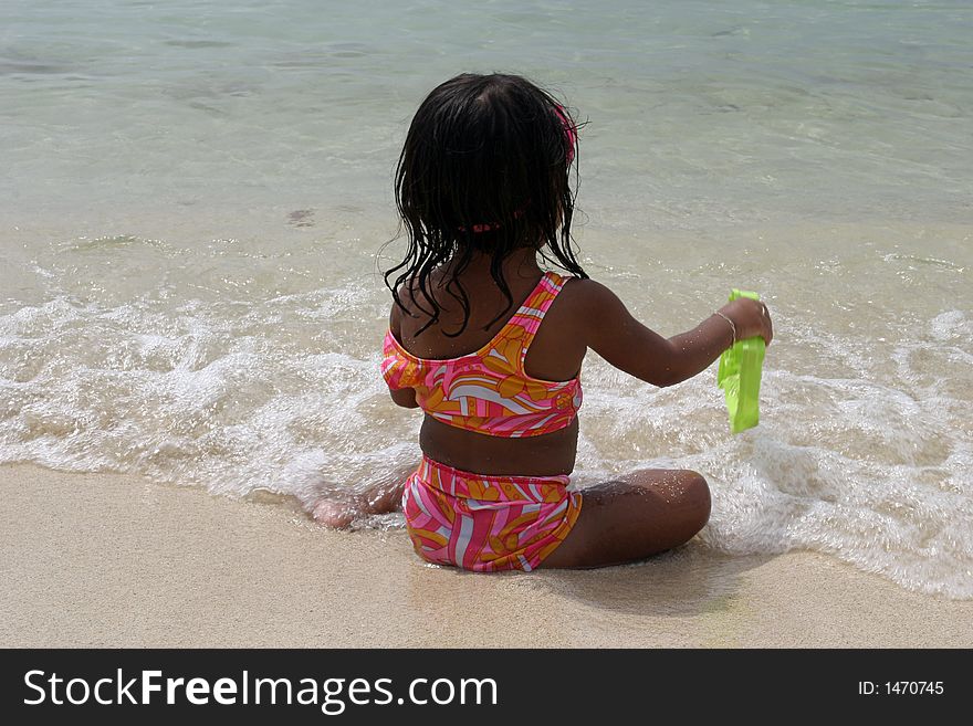 Little girl playing in the sand on a beach. Little girl playing in the sand on a beach