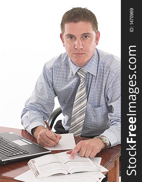 Businessman taking notes from the book on his desk over white. Businessman taking notes from the book on his desk over white