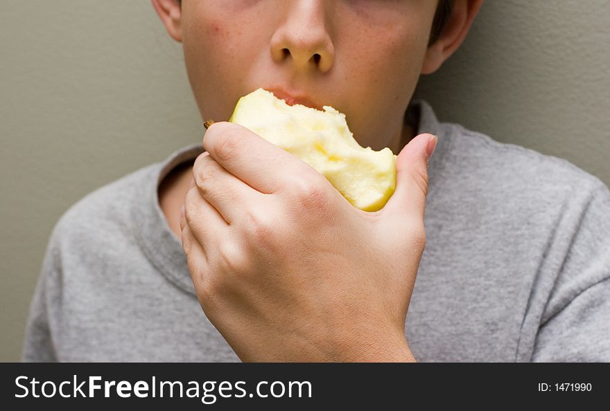Boy eating a golden delicious apple. Boy eating a golden delicious apple