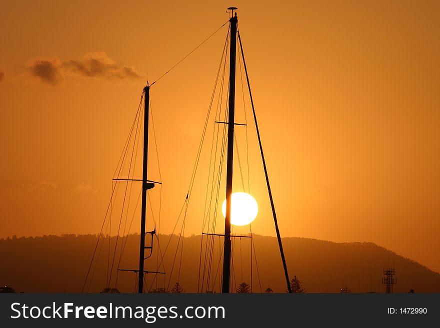 Two masts in the setting sun evoking a mood of a tropical paradise. Two masts in the setting sun evoking a mood of a tropical paradise.