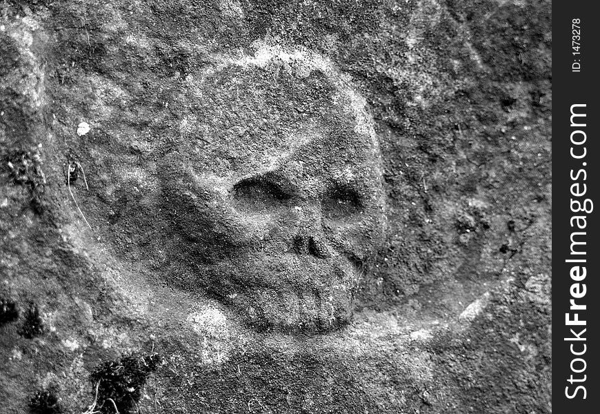Gravestone with detail of skull in black and white