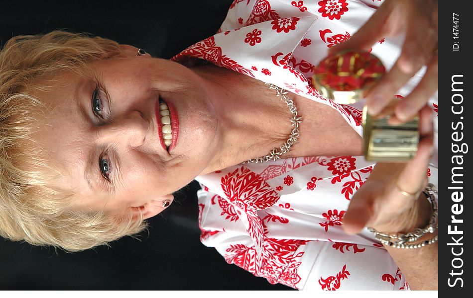 A senior woman holding a open christmas gift looking at camera(focus on woman). A senior woman holding a open christmas gift looking at camera(focus on woman)