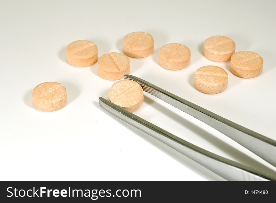 Photo of a Tweezer holding a pill  - Pharmaceutical Related. Photo of a Tweezer holding a pill  - Pharmaceutical Related