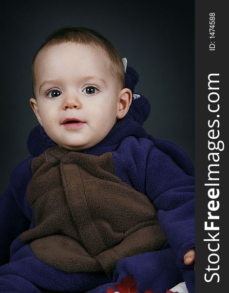 Beautiful baby boy poses on a black background