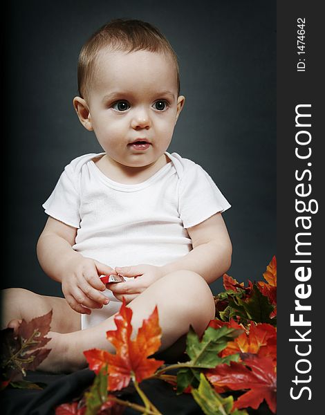 Beautiful baby boy poses on a black background