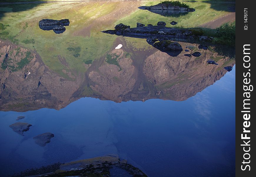 Mountain and sky reflected in alpine lake. Mountain and sky reflected in alpine lake