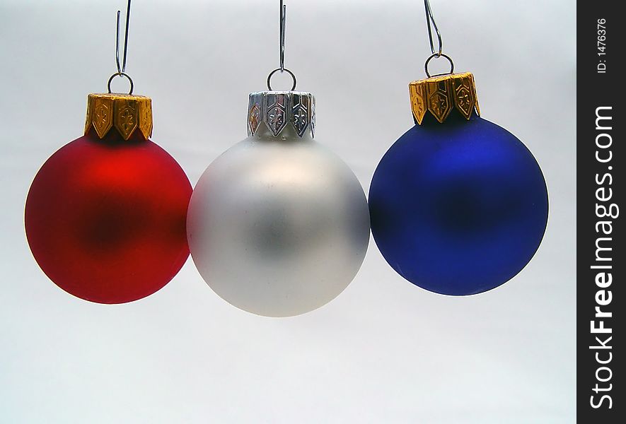 Various colored Xmas ornaments against a snowy background. Various colored Xmas ornaments against a snowy background