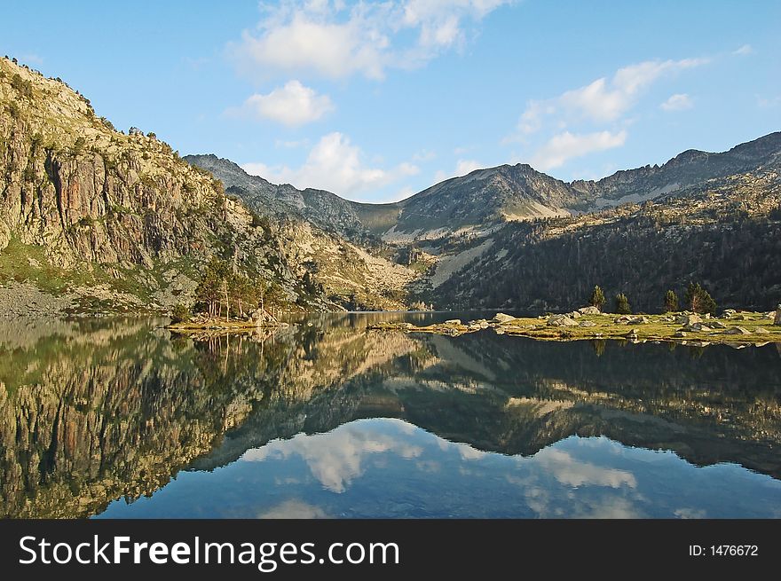 Mountains summits reflecting in a lake, Pyrenees mountains, France. Mountains summits reflecting in a lake, Pyrenees mountains, France