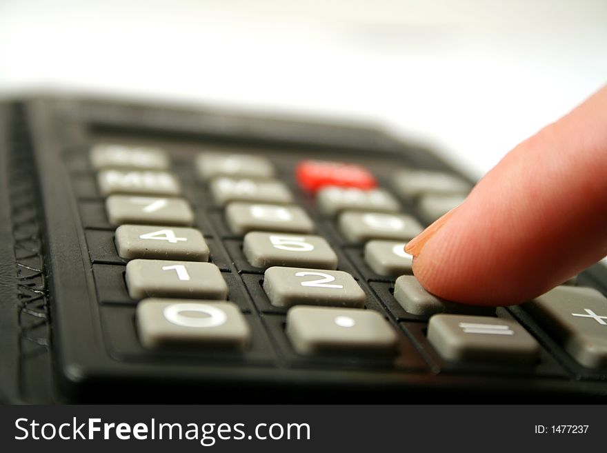 Close up of fingertip on the the keyboard of a calculator. Close up of fingertip on the the keyboard of a calculator.