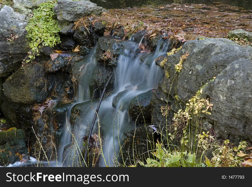 Water fall, backed up with fallen autumn leaves. Water fall, backed up with fallen autumn leaves