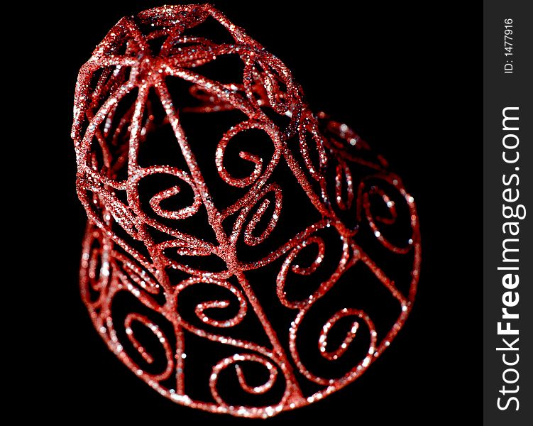 Red and sprakly christmas bell ornament on a black background