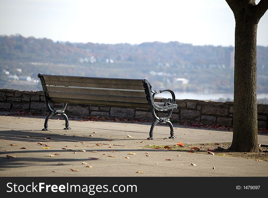 Sunny park bench with a view of the city. Sunny park bench with a view of the city