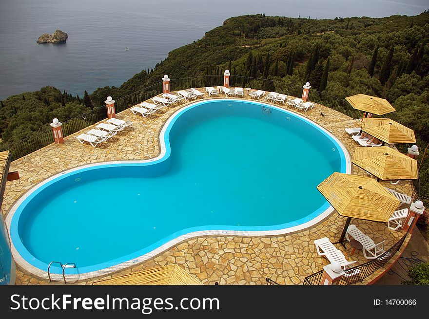 Outside swimming pool in hills overhanging the Ionian Sea on the coast of the island of Corfu, Greece. Outside swimming pool in hills overhanging the Ionian Sea on the coast of the island of Corfu, Greece.